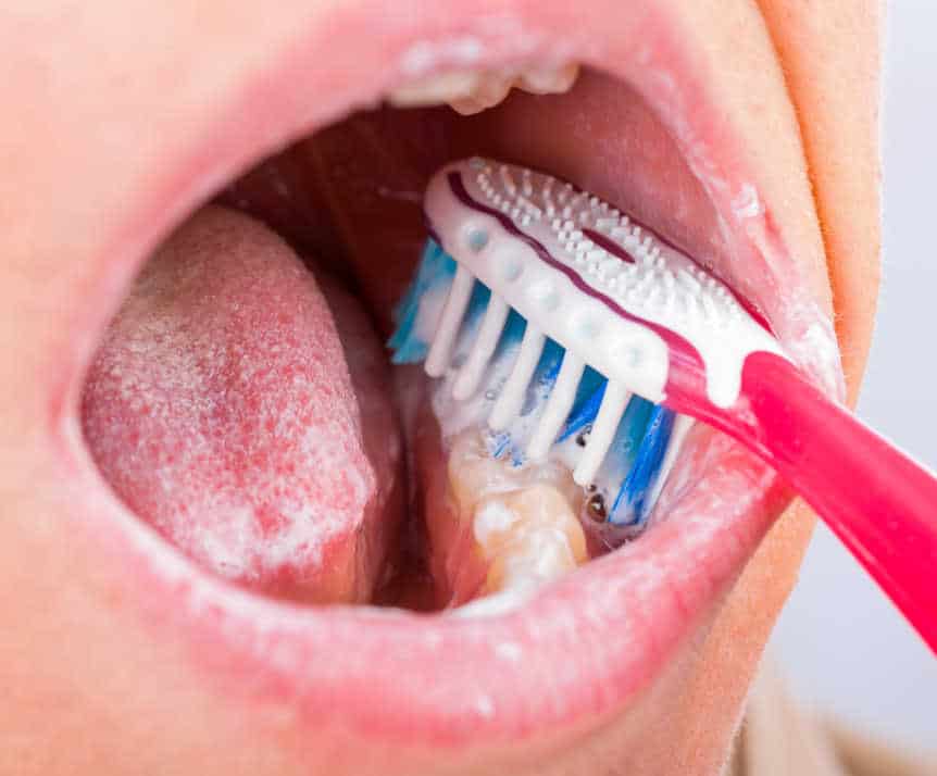 Proper oral hygiene tools, including toothbrush, floss, and mouthwash, essential for maintaining white teeth Reading